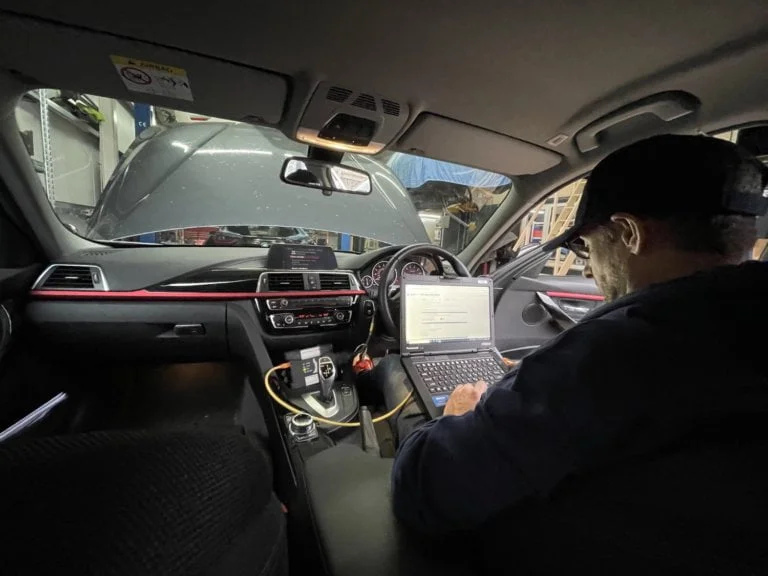 BMW under bonnet with tech standing
