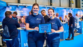 maverick employees holding certificate at trade stand