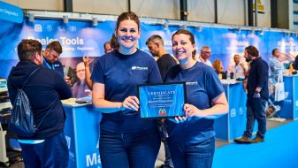 maverick employees holding certificate at trade stand